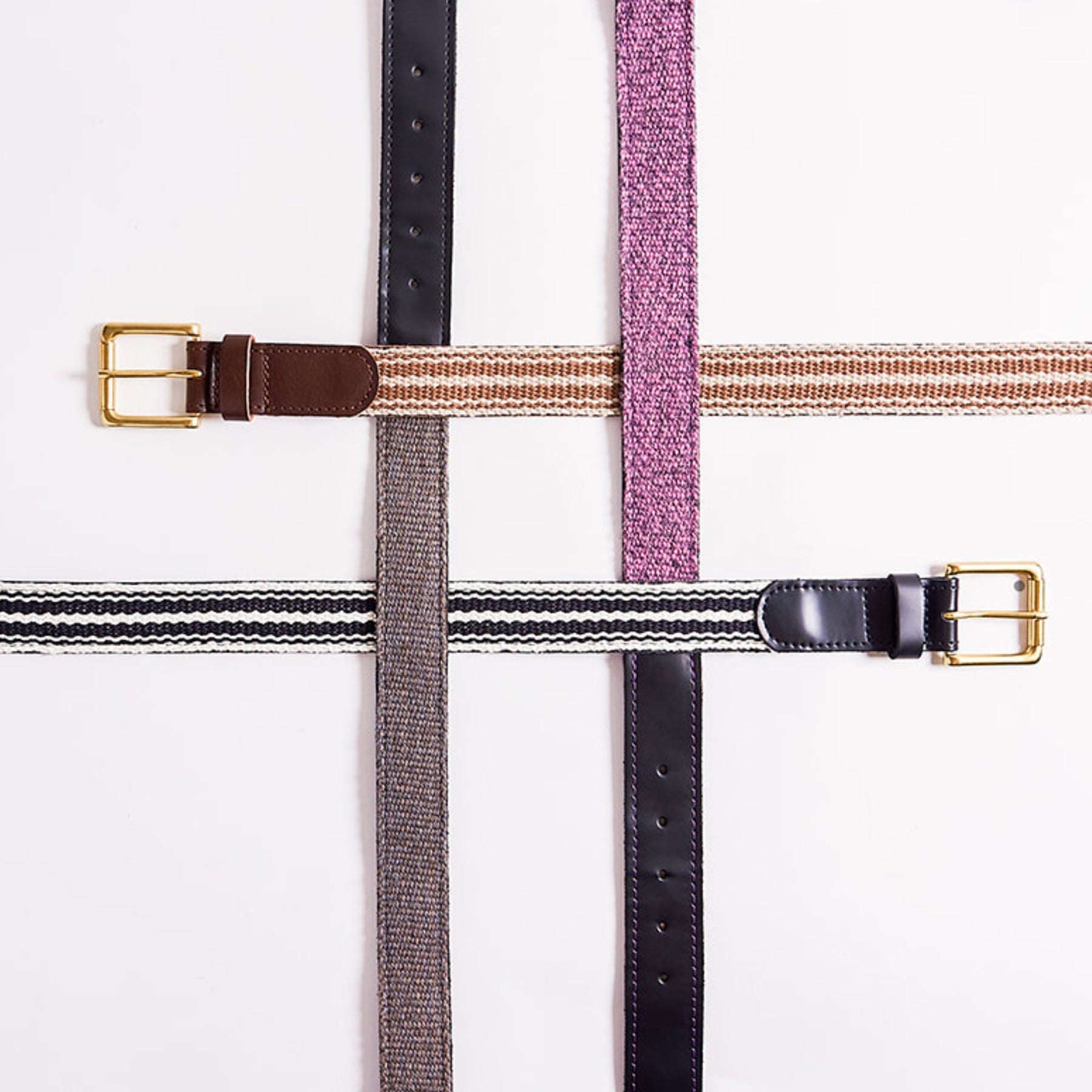 Collection of belts with gold buckles on a white background
