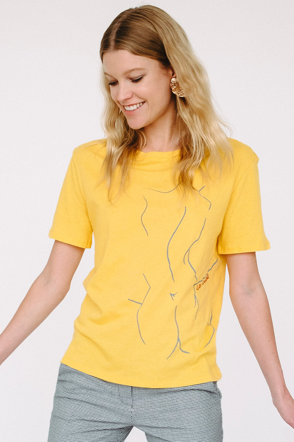 Model wearing Co-Exist Tee in Yellow with hand embroidery